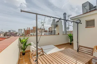 a balcony with a wooden bench on a roof at Ola Living Vidreria in Barcelona
