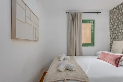 a white bedroom with a teddy bear sitting on a bed at Ola Living Vidreria in Barcelona