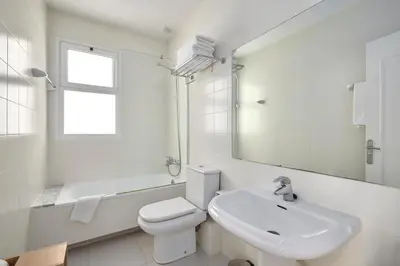 a white bathroom with a toilet and a sink at Fisa Rentals Aribau in Barcelona