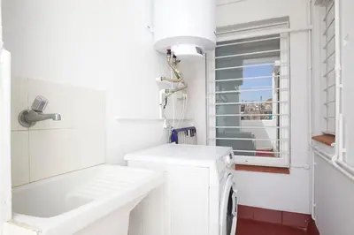 a white bathroom with a sink and a washing machine at Fisa Rentals Aribau in Barcelona