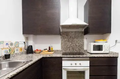 a kitchen with a sink and a microwave at Cal Mateu 11 huéspedes - Sagrada Família in Barcelona
