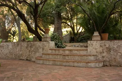 a set of stone stairs with trees in the background at Can Rovira - Stunning Neoclassical Mansion, Just 20 min drive from Barcelona City Center, Ideal for groups and families in Alella