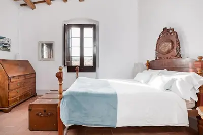 a bedroom with a large bed and a wooden dresser at Can Rovira - Stunning Neoclassical Mansion, Just 20 min drive from Barcelona City Center, Ideal for groups and families in Alella