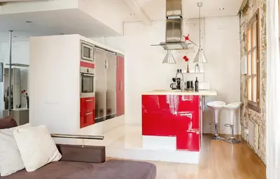 a living room with a red and white kitchen at Loft en Gràcia ArchsenseApartments in Barcelona