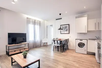 a kitchen and living room with a table and a dining room at Amister Apartments in Barcelona