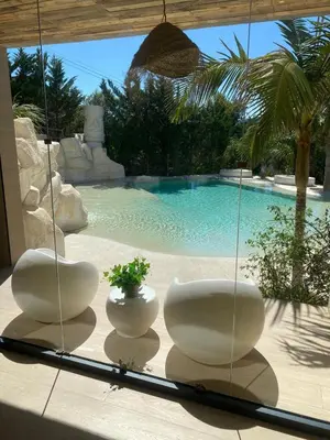 two white chairs sitting on a patio with a swimming pool at Petit Mirador in Torrelles de Llobregat