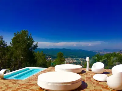 a pool with white chairs and a swimming pool at Petit Mirador in Torrelles de Llobregat