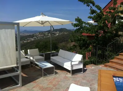 a patio with two chairs and an umbrella at Petit Mirador in Torrelles de Llobregat