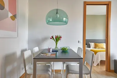 a dining room with a black table and white chairs at Lugaris Rambla Apartments in Barcelona
