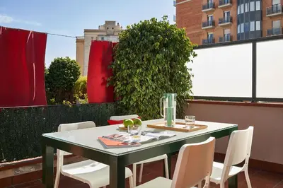 a green table and chairs on a balcony at Lugaris Rambla Apartments in Barcelona