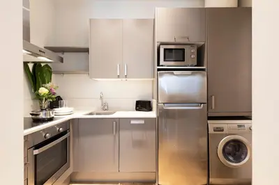 a kitchen with a stainless steel refrigerator and a microwave at Aspasios Urquinaona Apartments in Barcelona