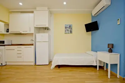 a kitchen with white cabinets and a white refrigerator at Barcelona City Apartment in Barcelona