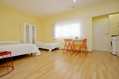 a room with two beds and a table and chairs at Barcelona City Apartment in Barcelona
