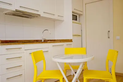 a kitchen with yellow chairs and a white table at Barcelona City Apartment in Barcelona