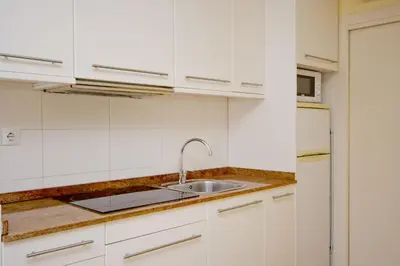 a kitchen with white cabinets and a sink at Barcelona City Apartment in Barcelona