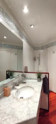 a bathroom with a sink and a large mirror at Gracia Apartment in Barcelona