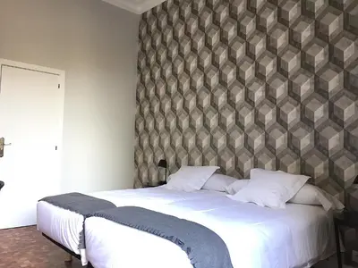 a bedroom with a large white bed with a wall at Hip Karma Hostel in Barcelona