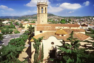 a large building with a clock tower in a city at AQUA Hotel Nostre Mar Apartments in Pineda de Mar