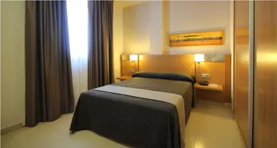 a hotel room with a bed and a window at AQUA Hotel Nostre Mar Apartments in Pineda de Mar