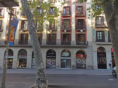 a building on the side of a street with stores at Hotel Lloret Ramblas in Barcelona
