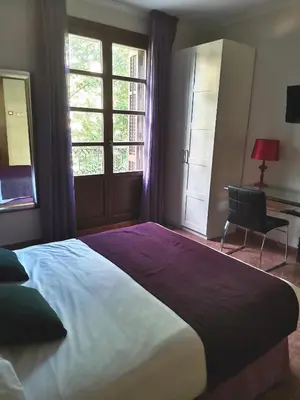a bedroom with a large bed and a desk and window at Hotel Lloret Ramblas in Barcelona