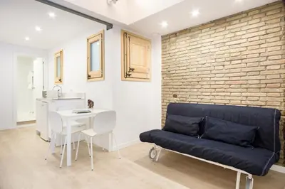 a living room with a couch and a brick wall at BcnStop Sagrada Familia in Barcelona