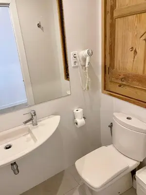 a bathroom with a toilet and a sink and a mirror at BcnStop Sagrada Familia in Barcelona