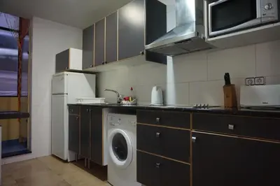 a kitchen with a washing machine and a washer at ApartEasy - Montjuïc & Fira in Barcelona