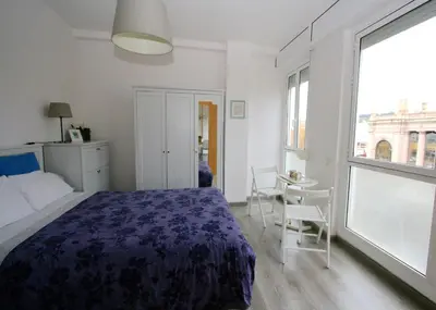 a bedroom with a bed and a table and chairs at ApartEasy - Plaza España Deluxe in Barcelona