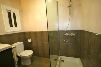 a bathroom with a toilet and a glass shower at ApartEasy - Plaza España Deluxe in Barcelona