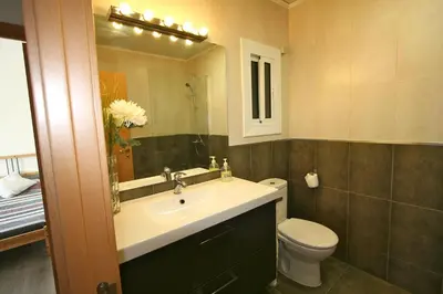 a bathroom with a sink and a toilet and a mirror at ApartEasy - Plaza España Deluxe in Barcelona