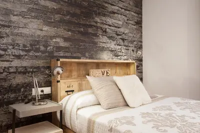 a bedroom with a bed and a wooden wall at Apartment Beach Front Canet in Canet de Mar