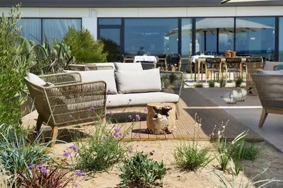 a couch sitting on a patio with some plants at Hotel Boutique dONNA in Castelldefels