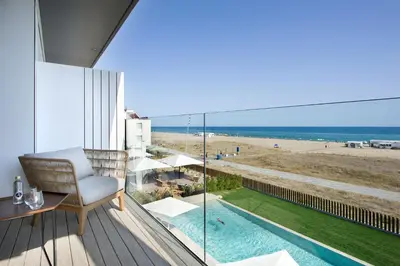 a balcony with a chair and a view of the beach at Hotel Boutique dONNA in Castelldefels