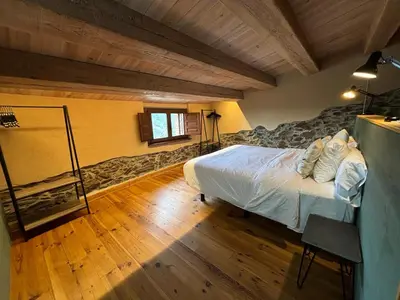 a bedroom with a bed and a wooden floor at Can Rovira de Fogars in Montseny