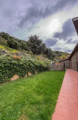 a garden with a fence and a grass field at Can Rovira de Fogars in Montseny