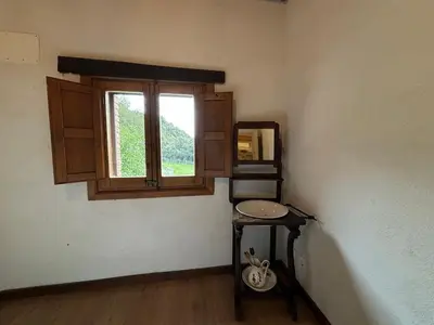 a small room with a table and a window at Can Rovira de Fogars in Montseny
