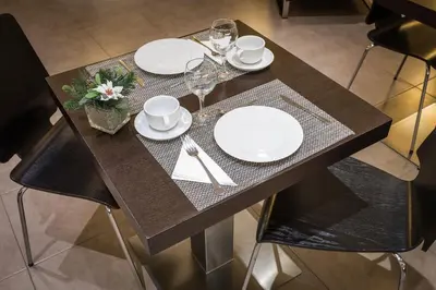 a wooden table with white plates and wine glasses at SM Hotel Teatre Auditori in Barcelona