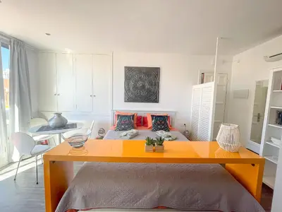 a bedroom with a bed and a table in it at Unique studio Apartment with amazing terrace Sitges centre beach in Sitges