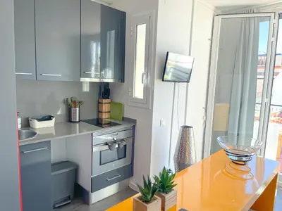 a kitchen with a table and a counter top at Unique studio Apartment with amazing terrace Sitges centre beach in Sitges