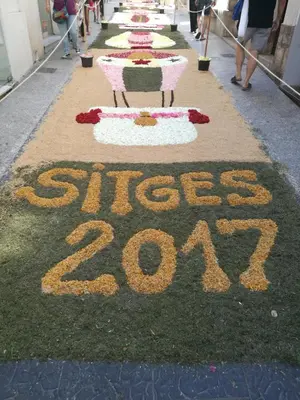 a row of tables with flowers on the grass at Unique studio Apartment with amazing terrace Sitges centre beach in Sitges