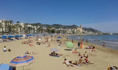 a group of people laying on the beach at Unique studio Apartment with amazing terrace Sitges centre beach in Sitges