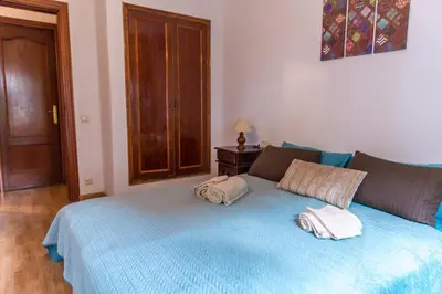 a bedroom with a blue bed with two pillows on it at 3 bedroom Apartment with private garden on top location Sitges centre beach in Sitges
