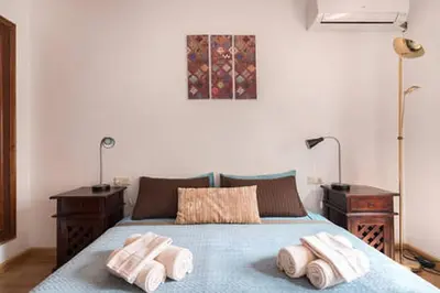 a bedroom with a blue bed with two towels on it at 3 bedroom Apartment with private garden on top location Sitges centre beach in Sitges