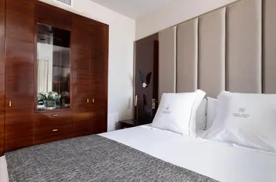 a bedroom with a white bed with a wooden headboard at Suites Center Barcelona in Barcelona
