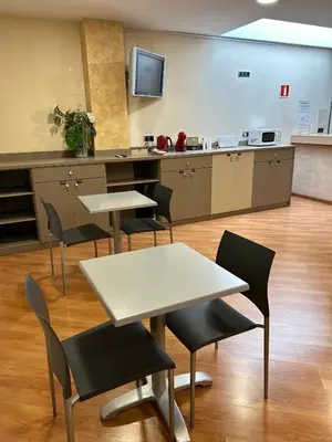 a room with tables and chairs and a kitchen at Hotel 1948 Manresa in Manresa