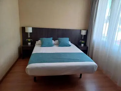 a bedroom with a large bed with blue pillows at Hotel 1948 Manresa in Manresa