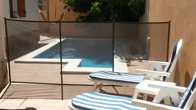 a pair of chairs and a swimming pool in a house at Casa Mar y Piscina (solo familias) in Sant Cebrià de Vallalta