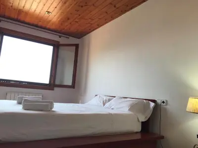 a bedroom with a large bed with a window at Casa Mar y Piscina (solo familias) in Sant Cebrià de Vallalta