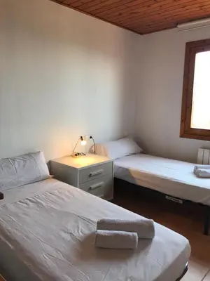 a bedroom with two beds and a desk with a lamp at Casa Mar y Piscina (solo familias) in Sant Cebrià de Vallalta
